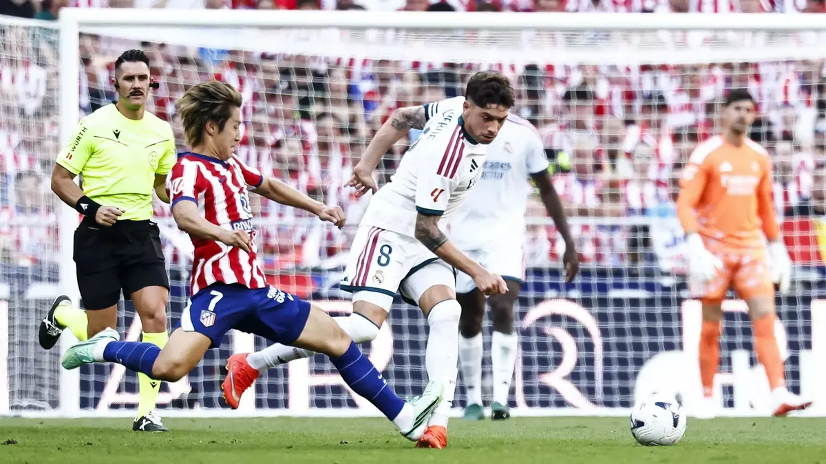 Fede Valverde của Real Madrid tranh bóng với cầu thủ Atlético trong trận derby tại Metropolitano